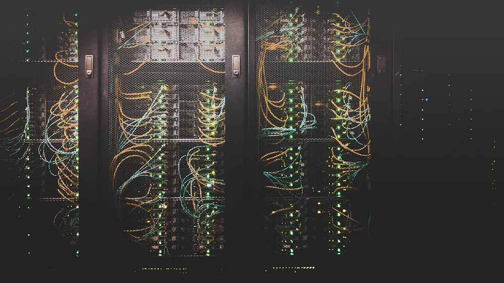 Corredor de um data center com fileiras de servidores iluminados por luz azul